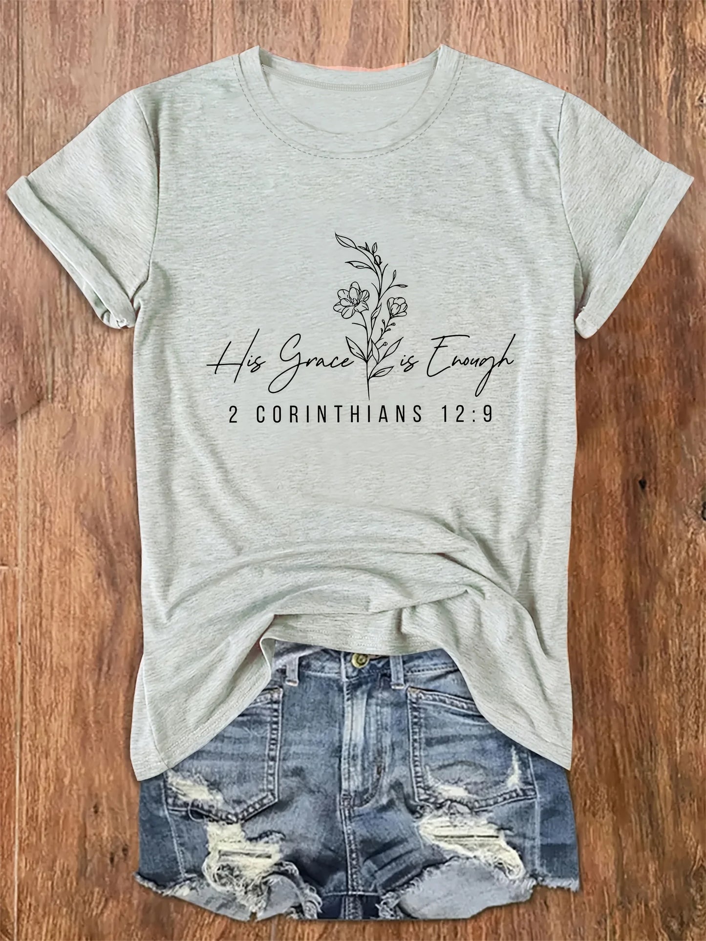 Gray t-shirt with 'His Grace is Enough' text on a wooden surface