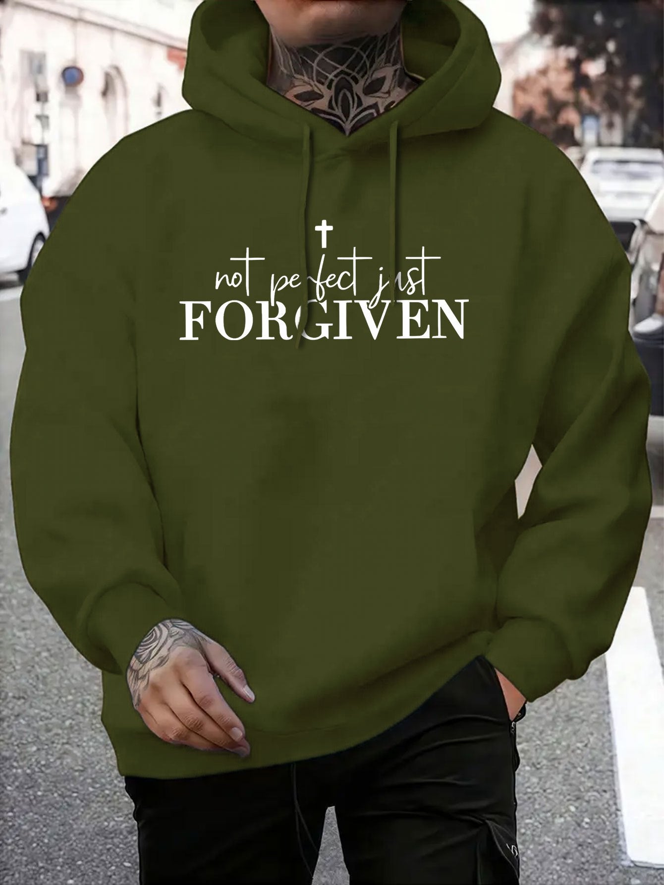 Person wearing a green hoodie with 'not perfect just FORGIVEN' text.