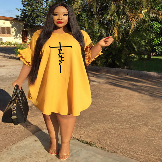 Woman wearing a yellow dress with 'Faith' printed on it