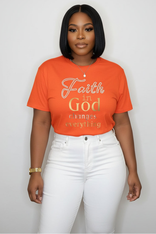 Person wearing an orange t-shirt with 'Faith in God changes everything' text.