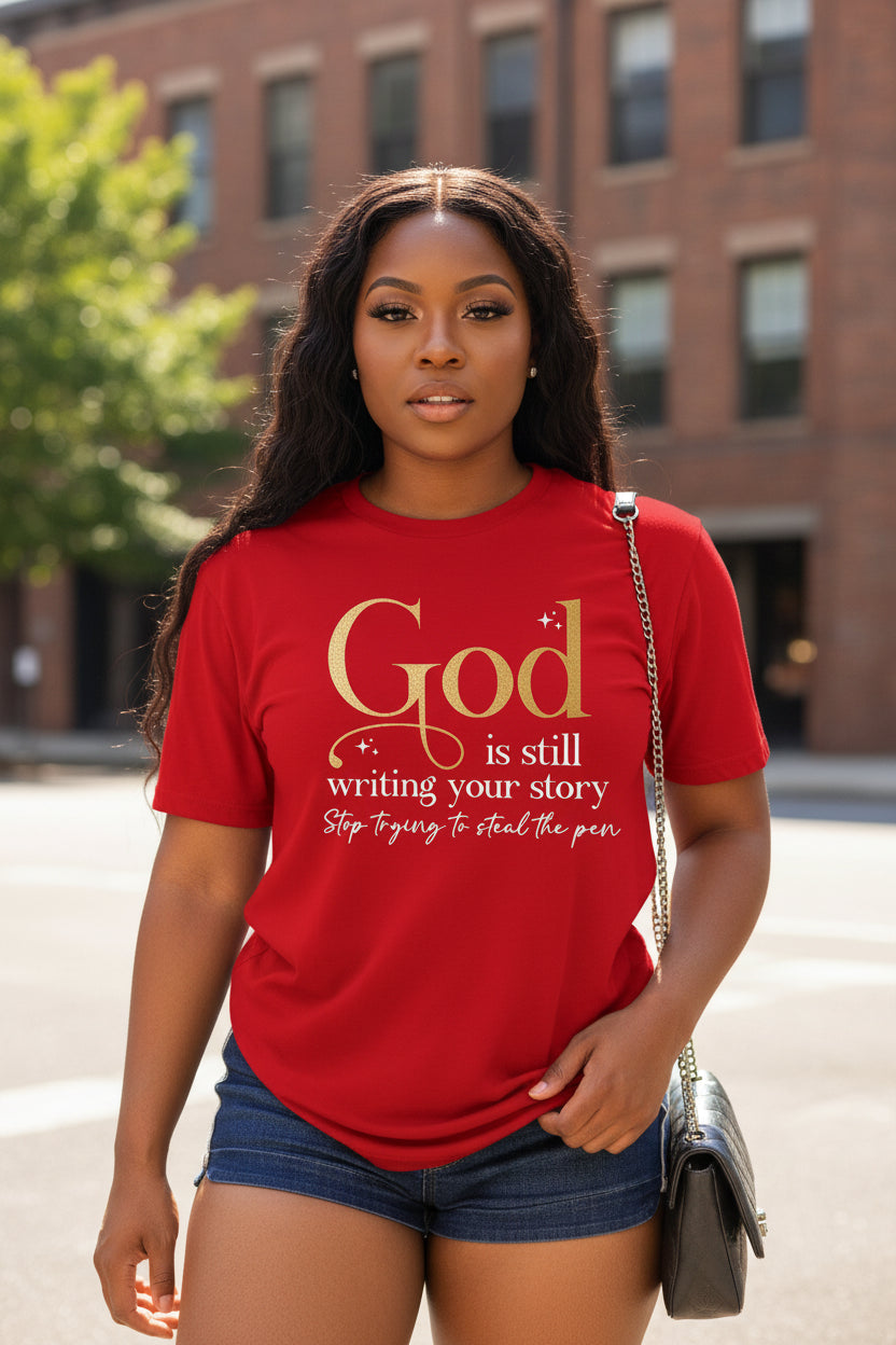 Woman wearing a red Christian graphic T-shirt featuring the message "God Is Still Writing Your Story. Stop Trying to Steal the Pen."