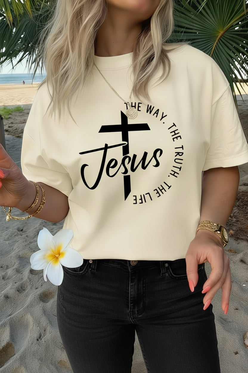 Person wearing a t-shirt with 'Jesus The Way, The Truth, The Life' design on a beach.