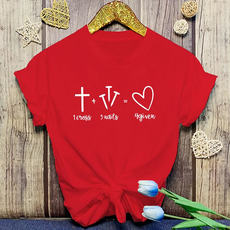 Red t-shirt with a white graphic and text on a wooden surface with decorative items.