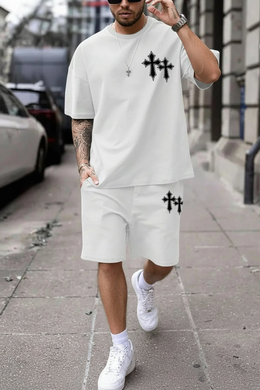 Man wearing a white outfit with black cross designs on a city street.