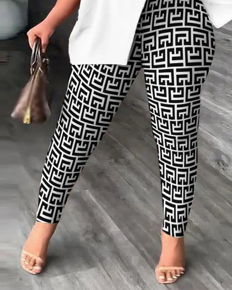 Black and white geometric patterned leggings worn by a model, styled with a white top, clear strap heels, and a brown handbag on a gray wood floor.
