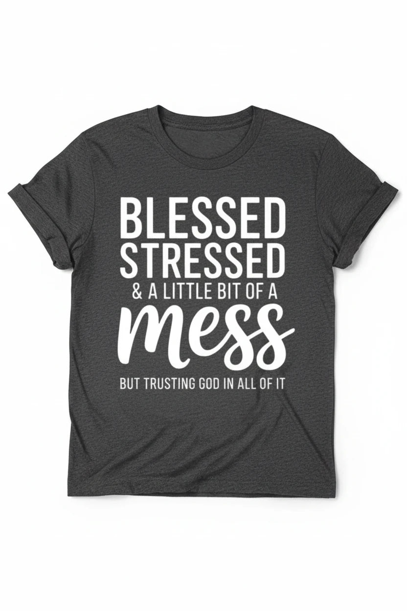 A dark gray heather graphic t-shirt with white text reading 'BLESSED STRESSED & A LITTLE BIT OF A mess BUT TRUSTING GOD IN ALL OF IT', styled on a white background with distressed blue jeans.