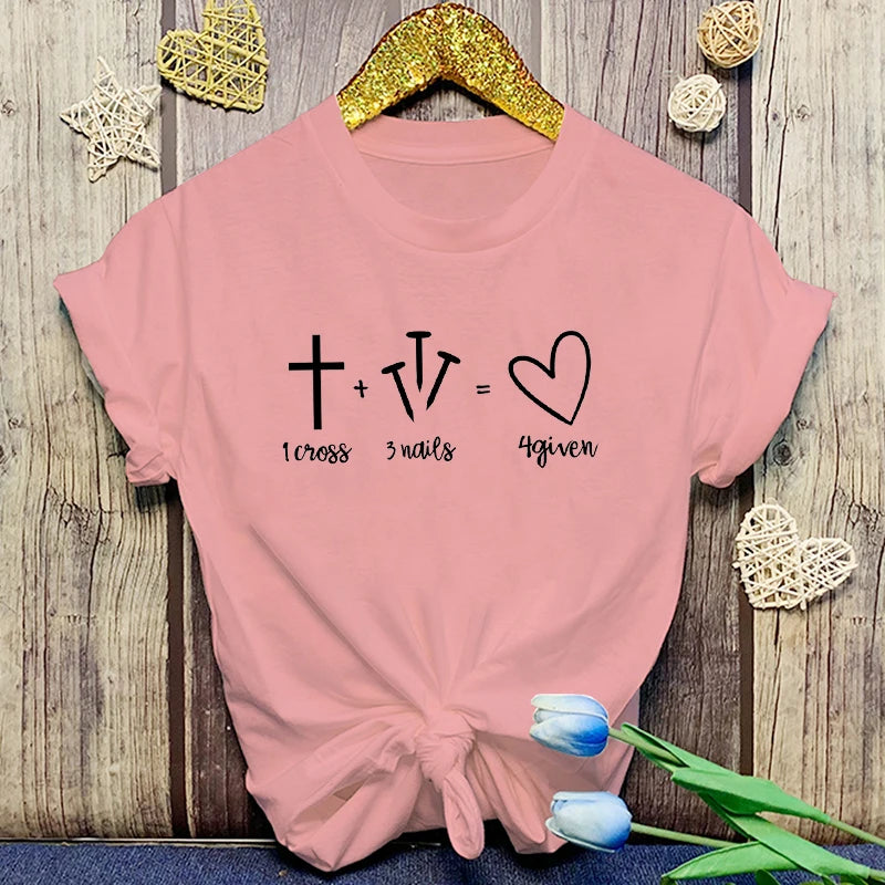 Pink t-shirt with a mathematical equation design on a wooden surface with decorative elements.