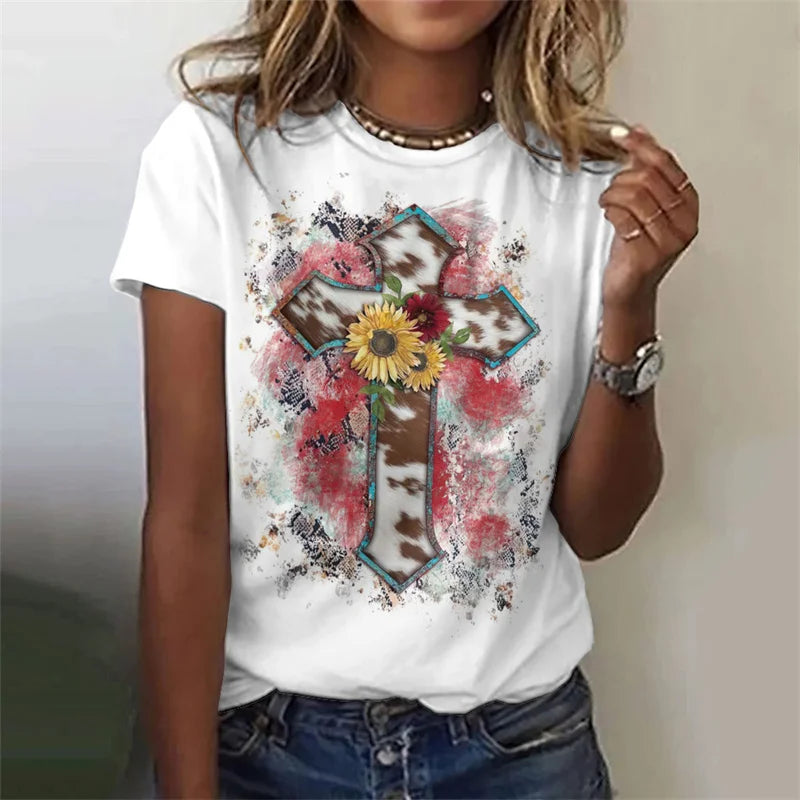Person wearing a white t-shirt with a colorful cross design featuring flowers and text.