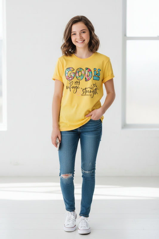 Yellow t-shirt with 'God is my refuge and strength' text on a wooden surface with jeans and sneakers.