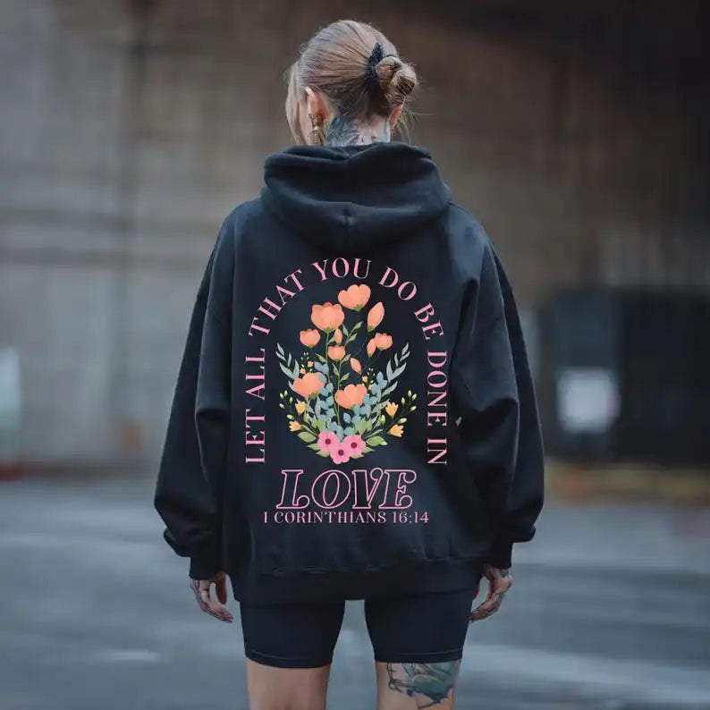 Person wearing a black hoodie with floral design and text on the back