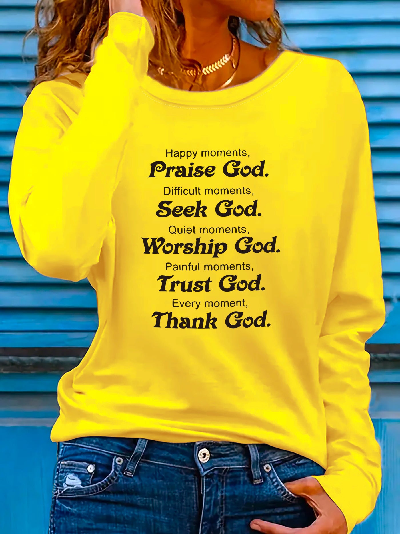 Person wearing a yellow t-shirt with inspirational text about praising, seeking, worshiping, trusting, and thanking God 