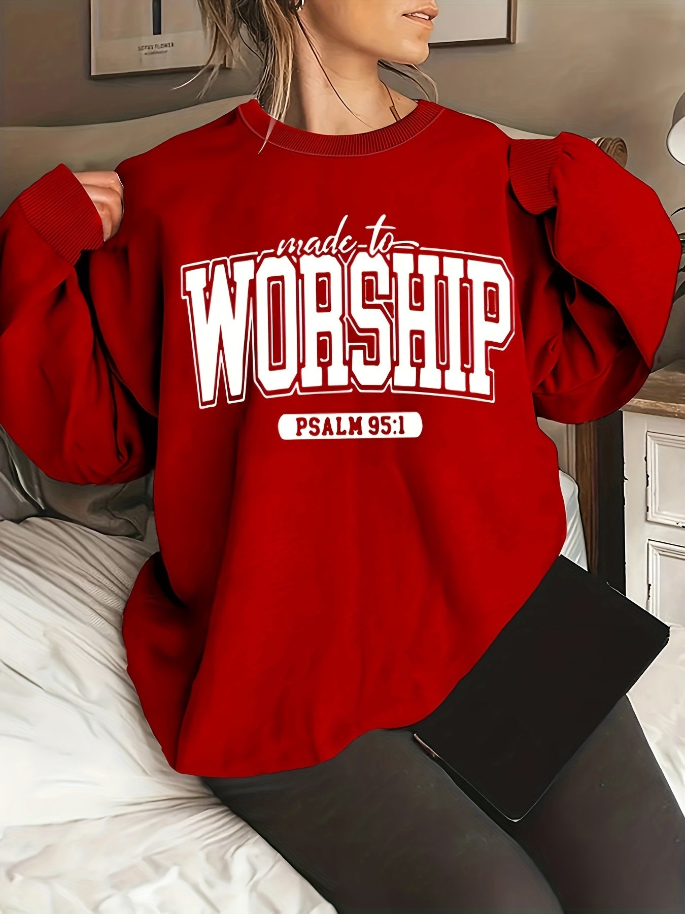 Person wearing a red sweatshirt with 'made to worship Psalm 95:1' text, 