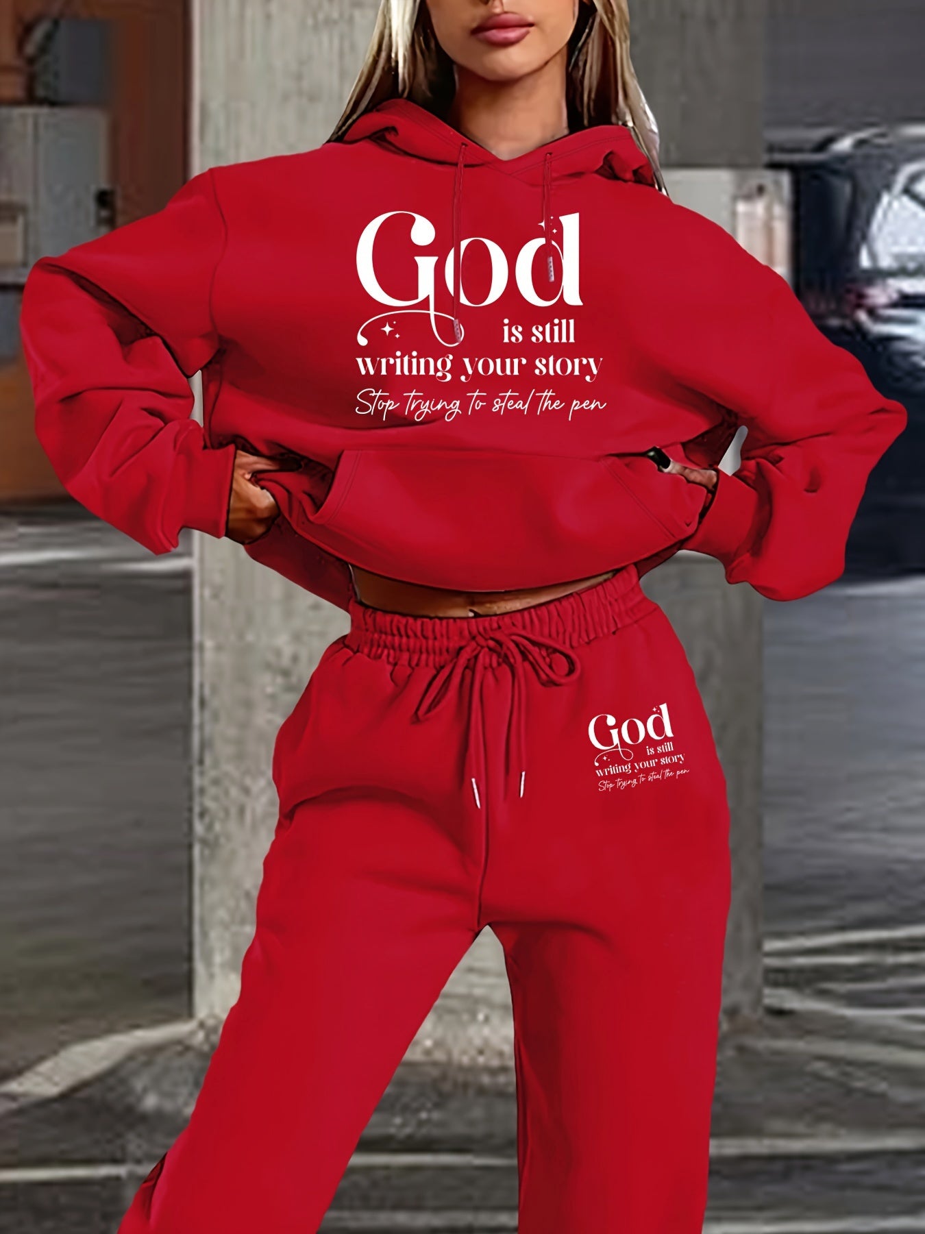 Red hoodie and pants set with motivational text, worn by a person outdoors.